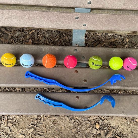 Lanceur de balle pour chien présenté avec plusieurs balles de jeu format tennis